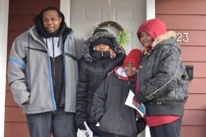 Gee Hunter and his family stand in front of their new Habitat for Humanity home  in Indianapolis. The home was sponsored by Carrier and built in part by Carrier employees.