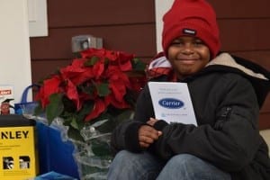 Keyonte Hunter, son of new Habitat homeowner Gee Hunter, sits outside his new home during the home dedication ceremony.